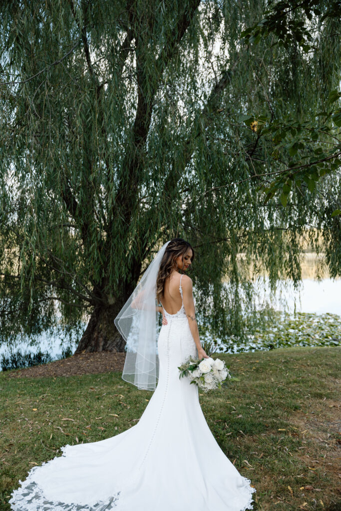 Bride sees bouquet overlooking lake