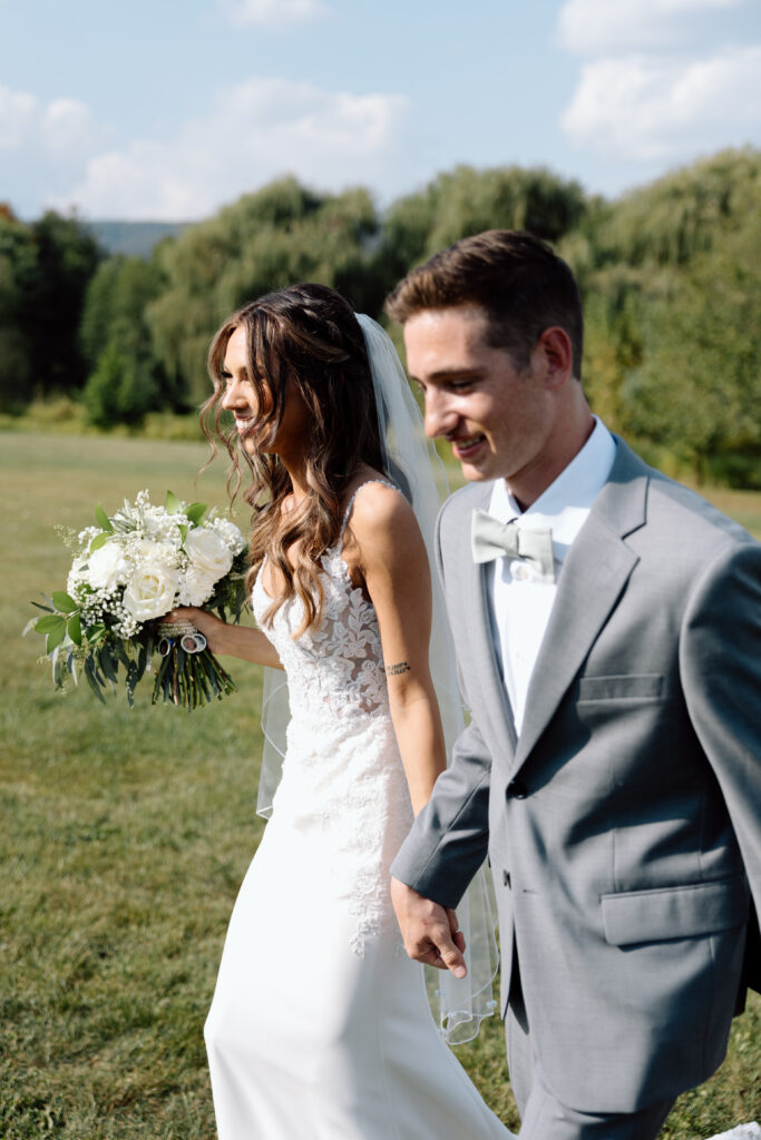 Bride and groom hold hands after outdoor wedding ceremony