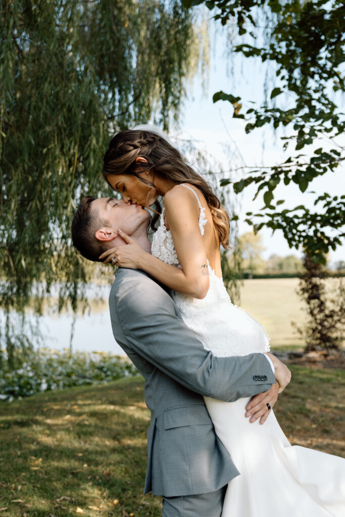 Couple kiss under tree outside Pennsylvania wedding venue