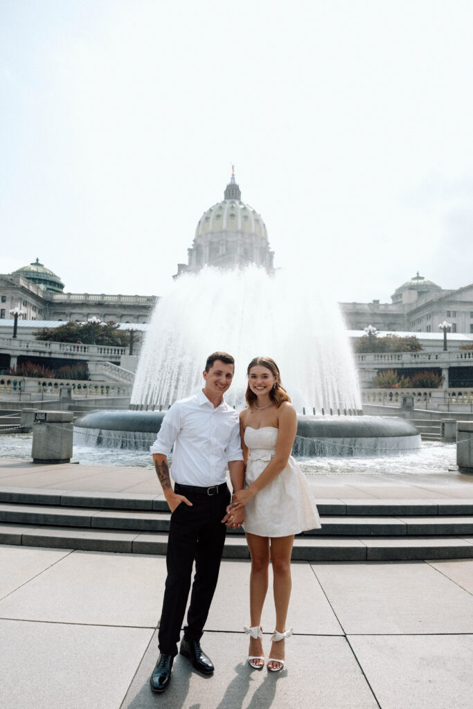 Engaged couple smile at the Pennsylvania State Capitol luxury engagement photos