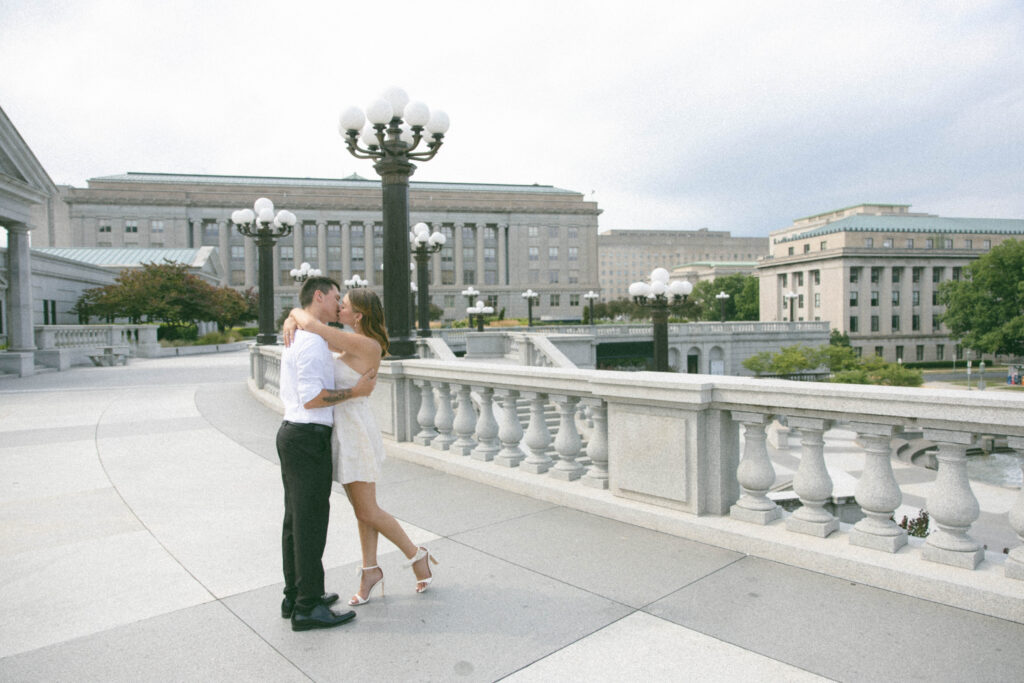 Engaged man and woman kiss outside the Pennsylvania Capitol Complex