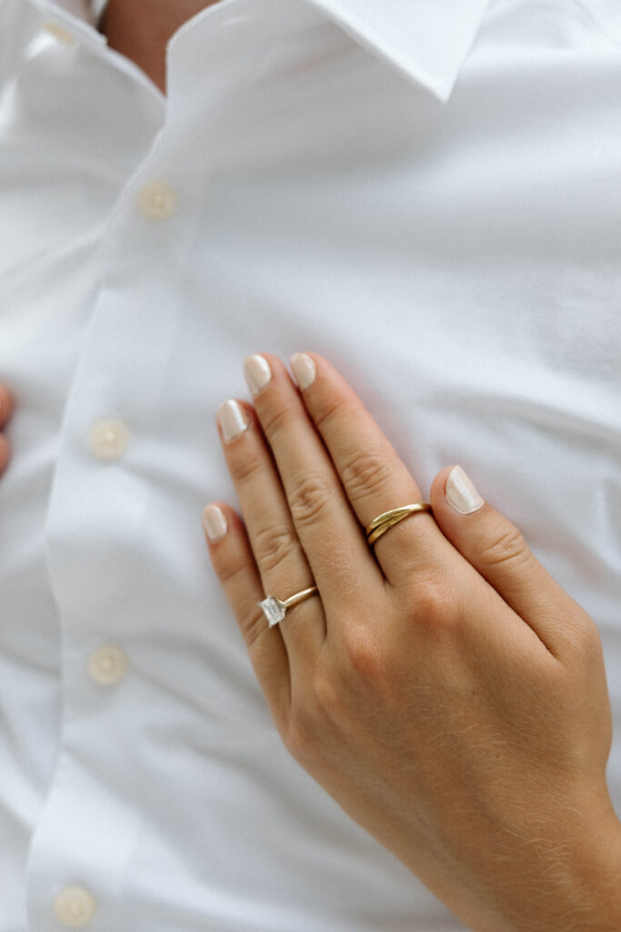 Beautiful engagement ring shines as hand caresses luxury engagement photos