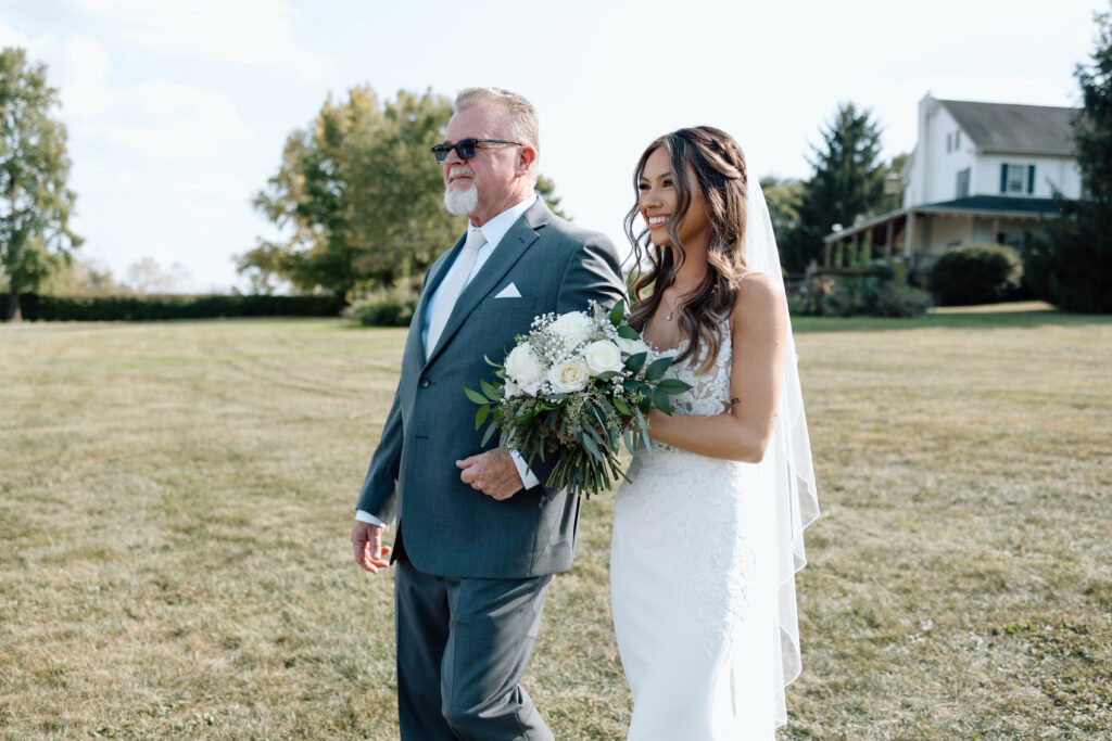 Father walks down the aisle in outdoor wedding ceremony