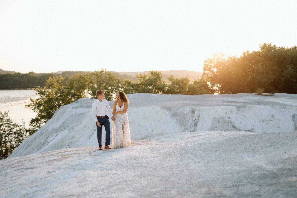 Couple smiling while walking hand in hand at White Cliffs of Conoy in Central PA.