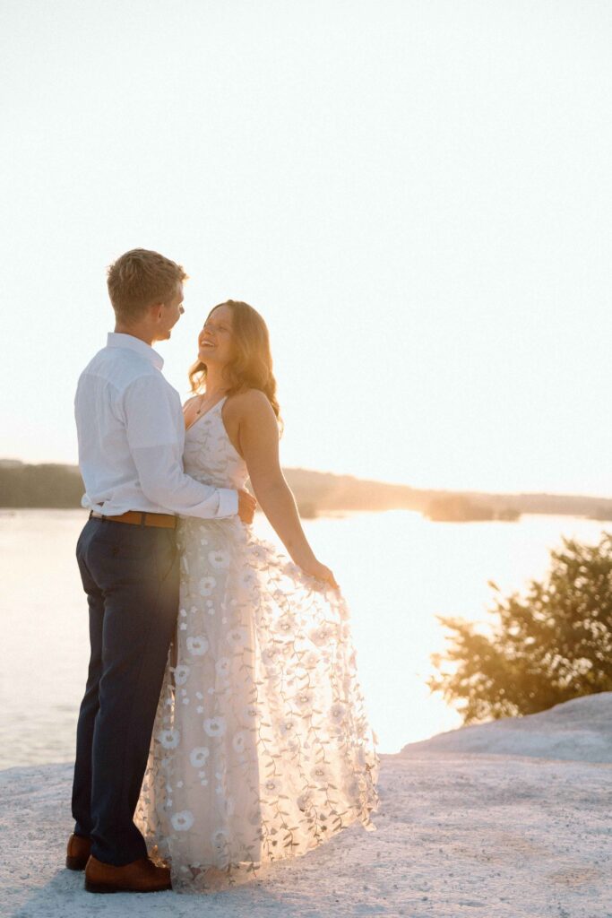 A newly engaged couple looking into each others eyes at sunset in front of the Susquehanna River in Central PA.