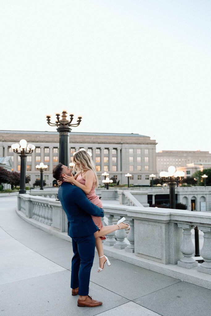 A man holding a woman in his arms while posing at the Pennsylvania State Capital.