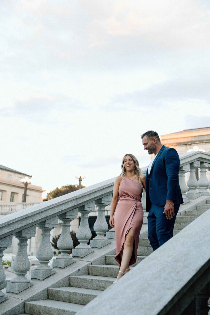 A couple walking down the steps at the PA State Capital for their engagement photography session.