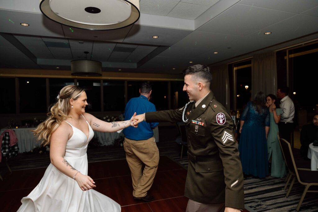 Newlyweds dancing together and smiling during their wedding in San Diego.