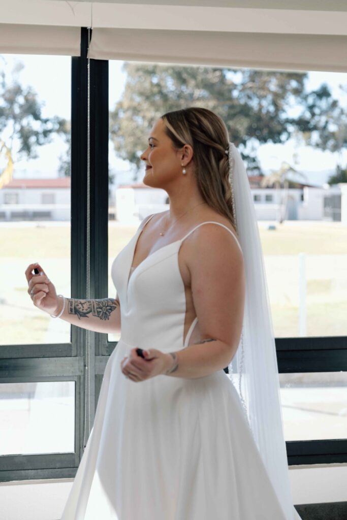 Bride putting on perfume.