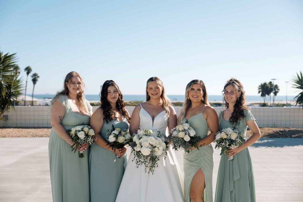 Bride and her bridesmaids smiling.