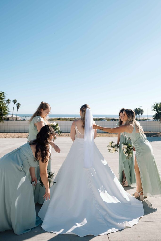 Bridesmaids making sure the bride is ready to walk down the aisle. 