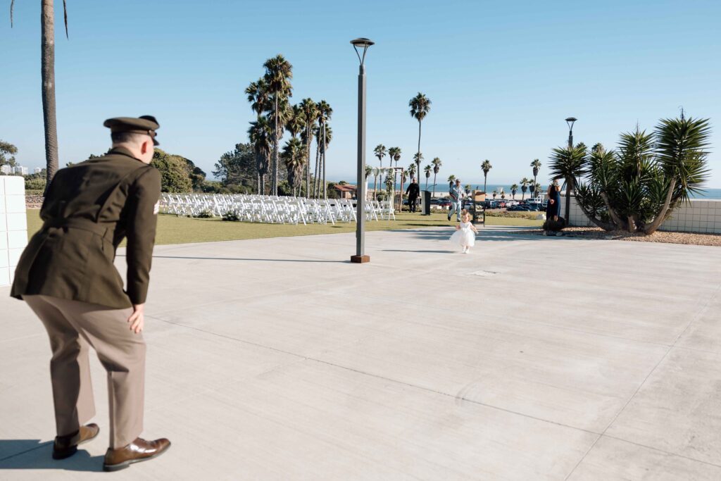 Groom having a first look with his daughter. The daughter is running towards her dad.