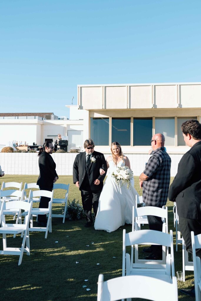 Bride walking down the aisle with her grandfather escorting her.