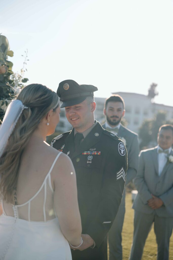 Groom smiling at his bride during their wedding in San Diego. 