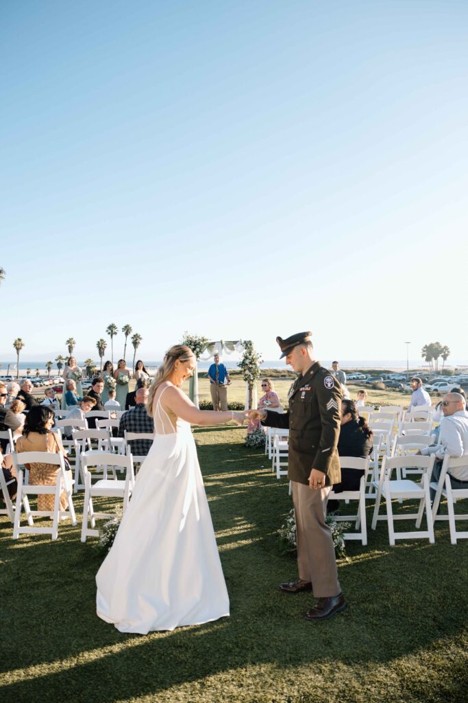 Newlywed couple playing a round of thumb war for their guests.