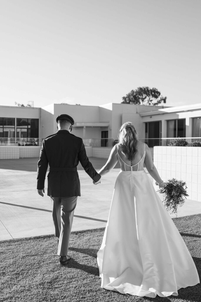 Newlywed couple walking away from the ceremony after their wedding in San Diego.