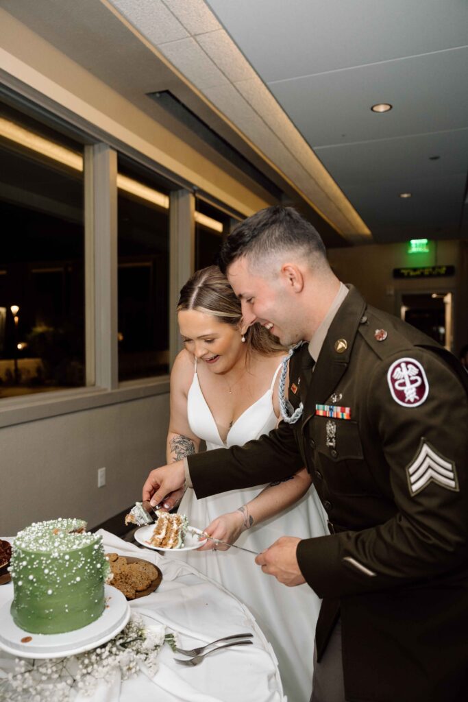 Married couple cutting cake and laughing.