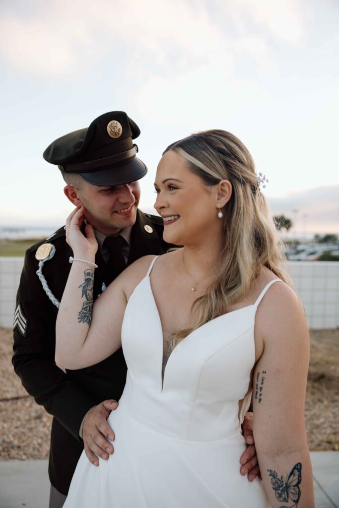 Close up of bride and groom smiling and holding one another.