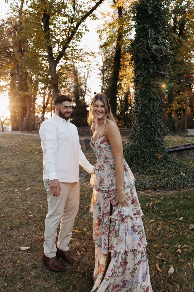 Couple smiling at sunset during their engagement photoshoot.