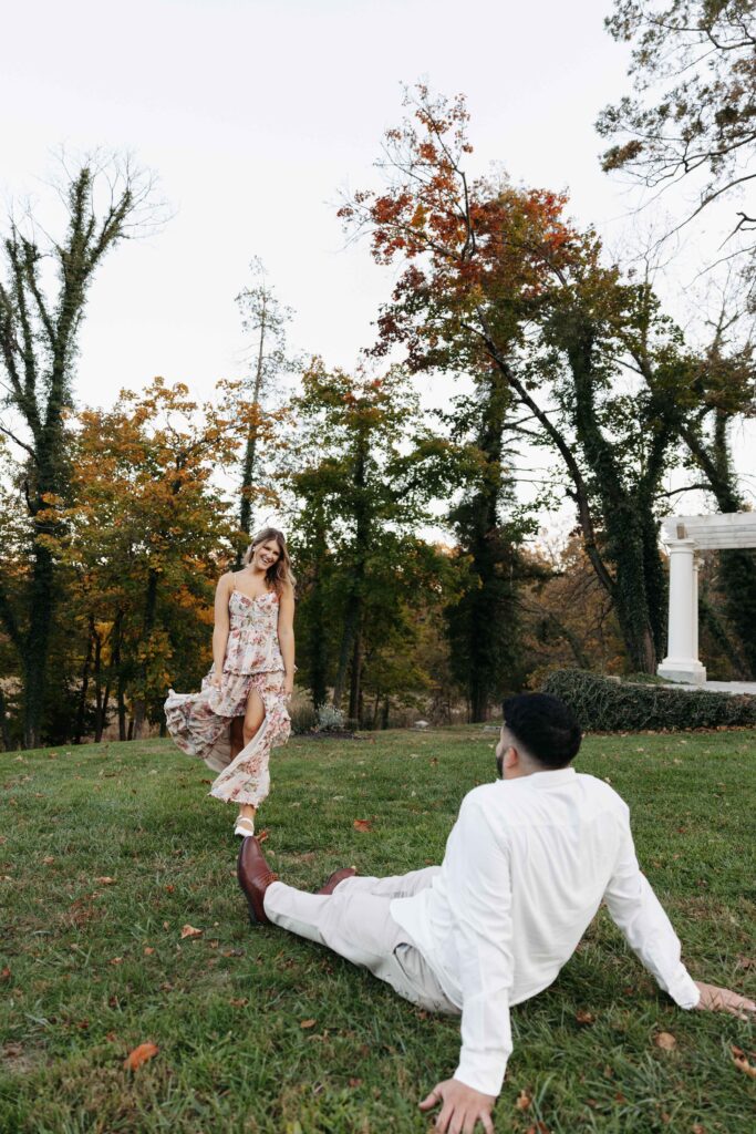 A woman playfully walking towards her fiance.