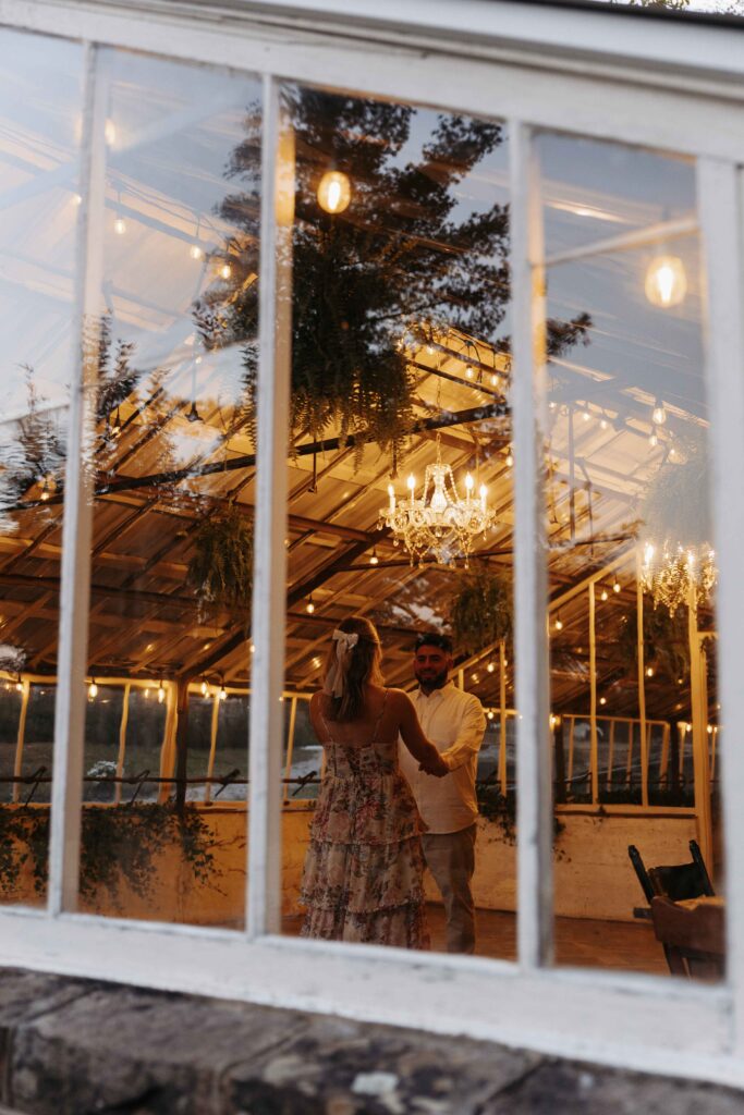 Couple dancing with warm lights around them.