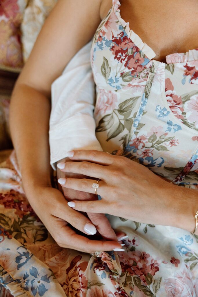 Close up of a floral dress and engagement ring.