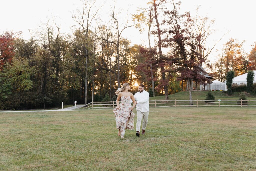 Couple playfully running in a field at Historic Shady Lane for their engagement photoshoot.