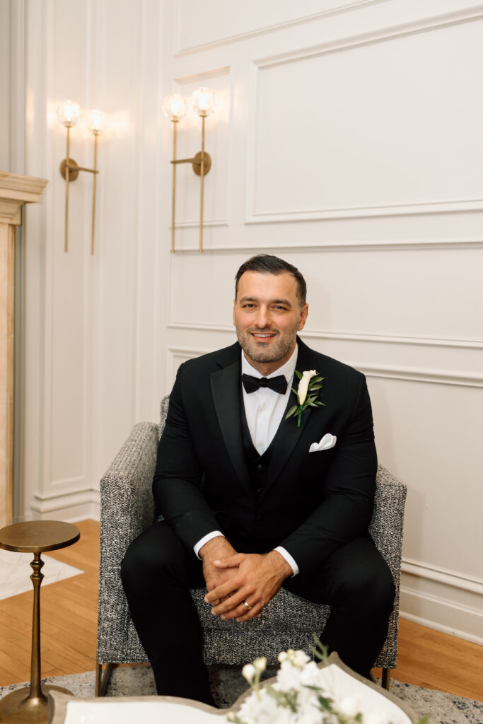 Portrait of the groom siting in his getting ready suite at Historic King Mansion. 