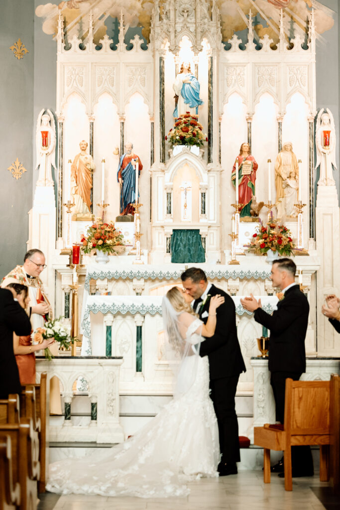 Bride and groom kissing at the altar in a church. 