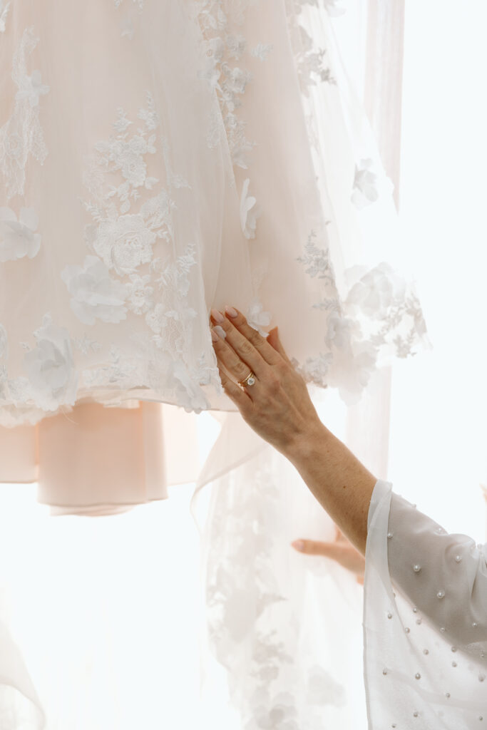 Close up of the brides wedding dress and her ring. 