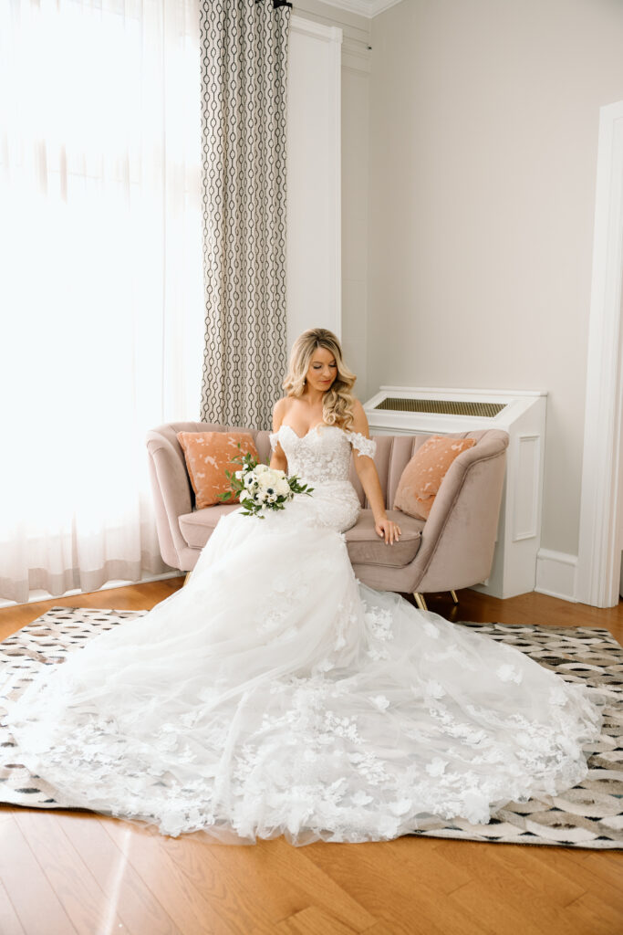 The bride in her wedding dress in her getting ready suite. 