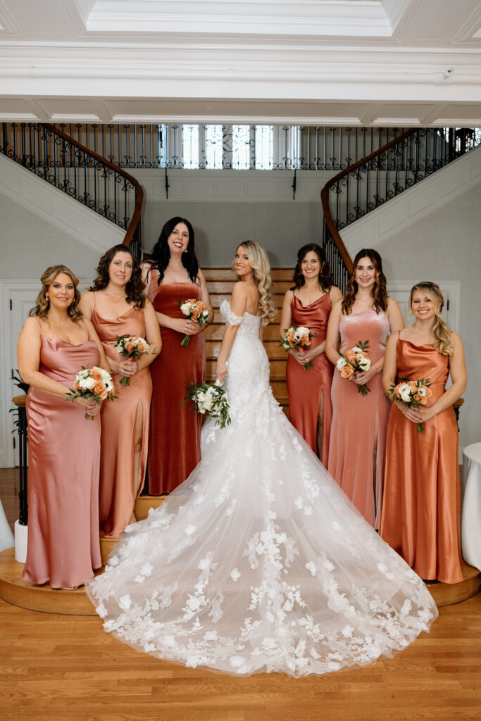 The bride and her bridesmaids posing on the staircase at King Mansion in Pennsylvania. 