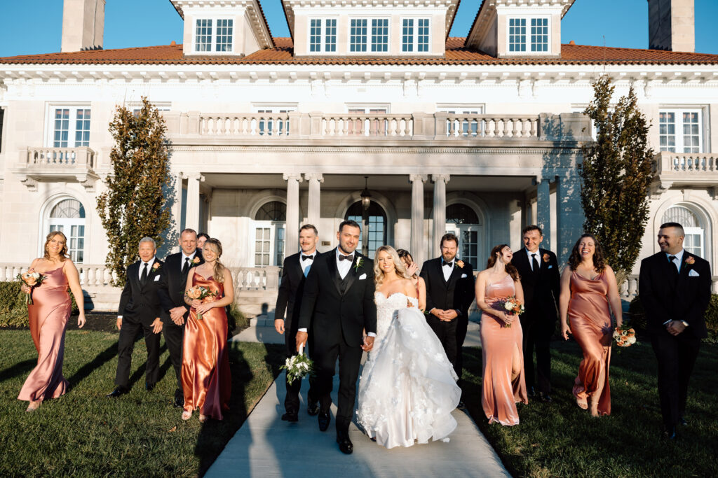 Elegant wedding photos of the bridal party talking and smiling outside at King Mansion.