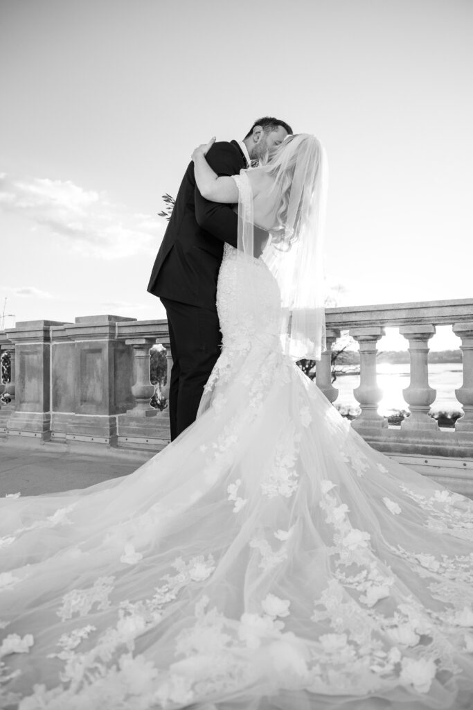 Elegant wedding photos of the newlyweds kissing on a terrace at King Mansion.