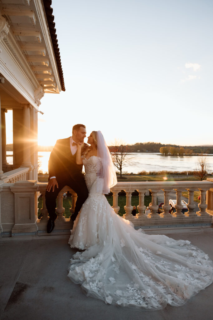 Bride and groom on the balcony at Historic King Mansion during golden hour.