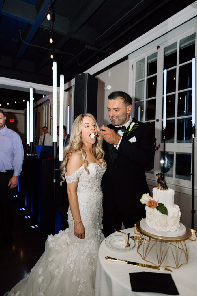 Groom feeding cake to his bride during their reception at King Mansion.