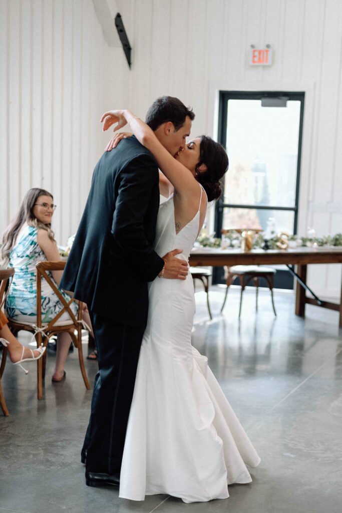 Newlyweds kissing as they dance at their black and white wedding.