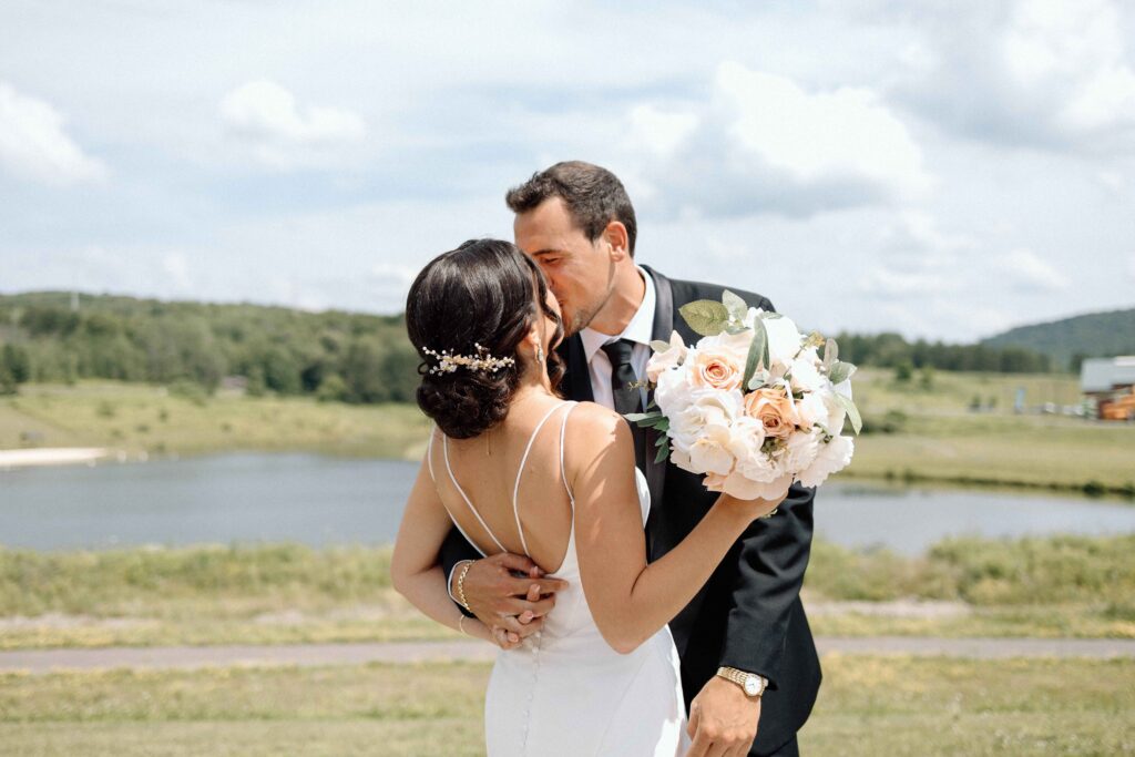 Bride and groom kissing passionately after their first look at The Lookout at Hope Lake.