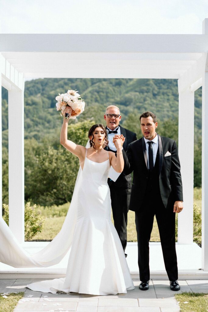 Bride and groom cheering in excitement over just being married.