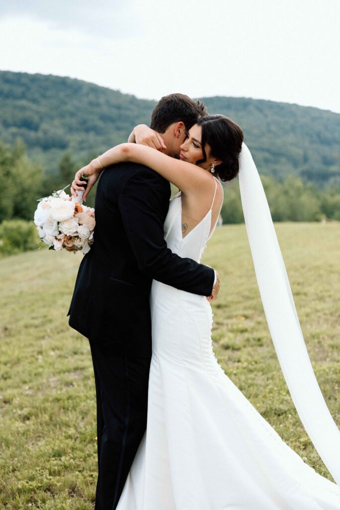 Bride and groom hugging romantically at The Lookout at Hope Lake.