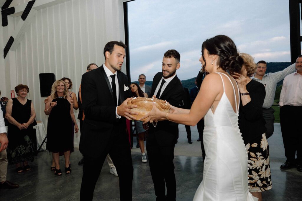 Bride and groom trying to break bread at their wedding reception at The Lookout at Hope Lake.