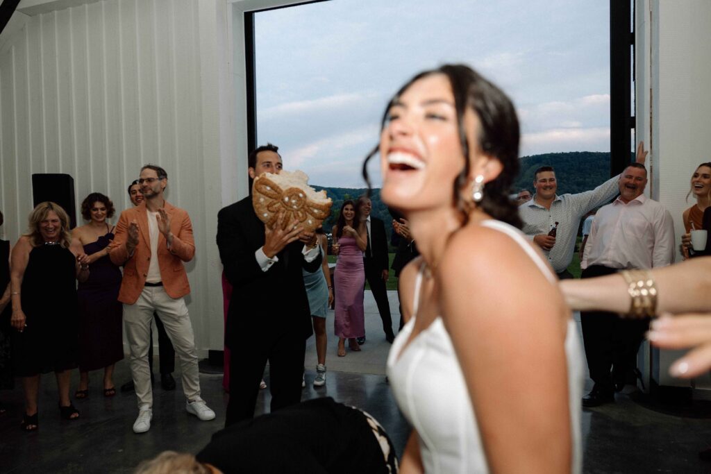 Bride laughing really hard after breaking the bread.