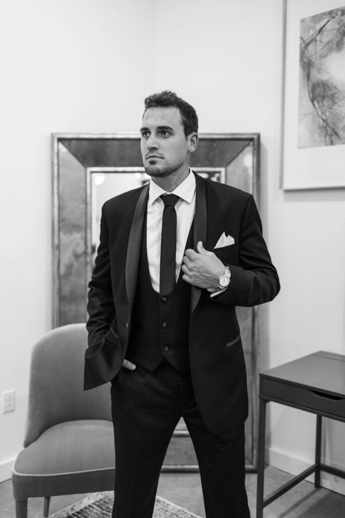 Groom all dressed and ready for his wedding wearing a black suit.