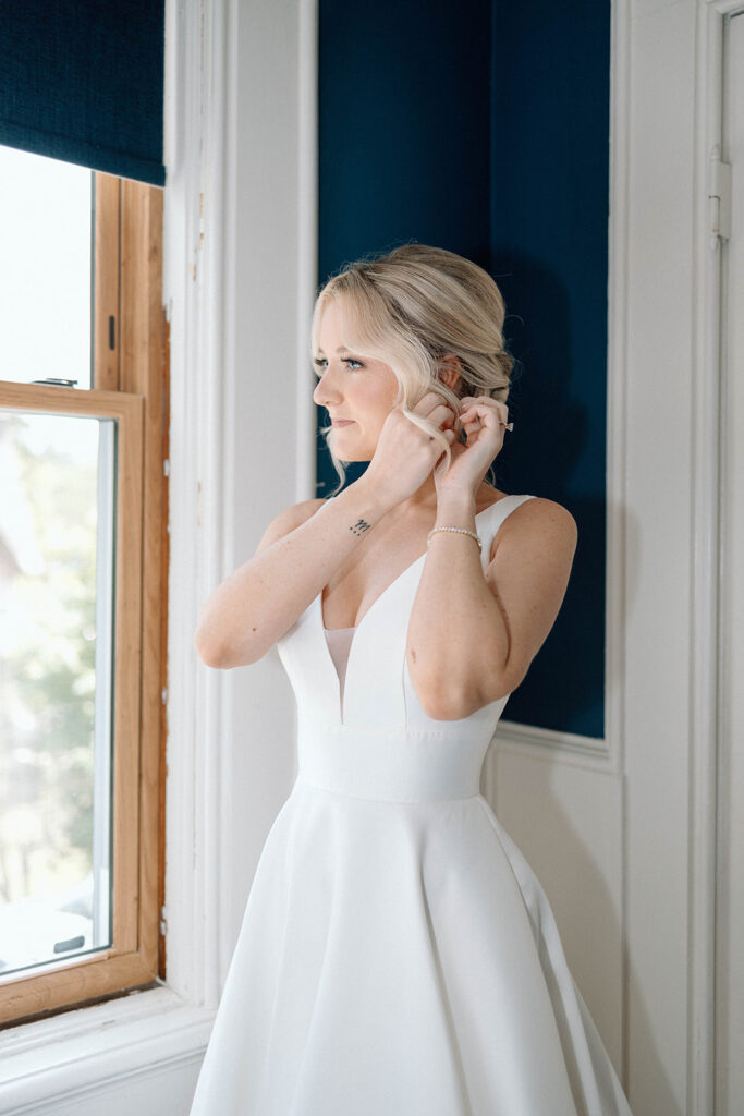 Bride putting on her earings.