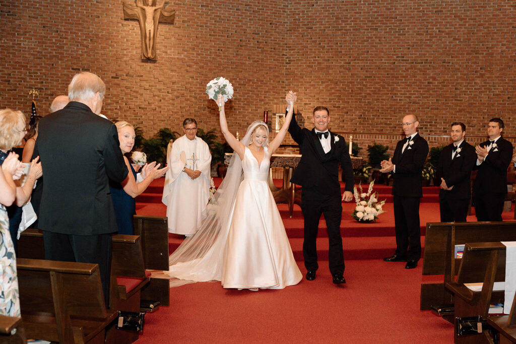 Bride and groom cheering after saying "I do" during their wedding ceremony before continuing their wedding photography timeline.