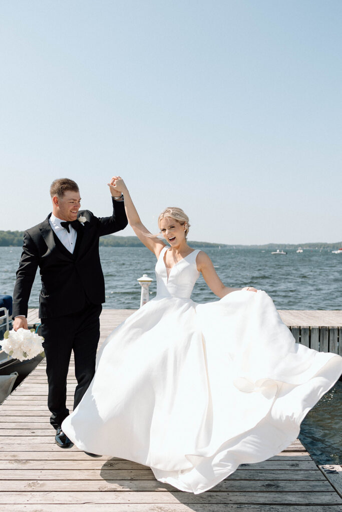 Bride swaying her dress and holding hands with the groom.