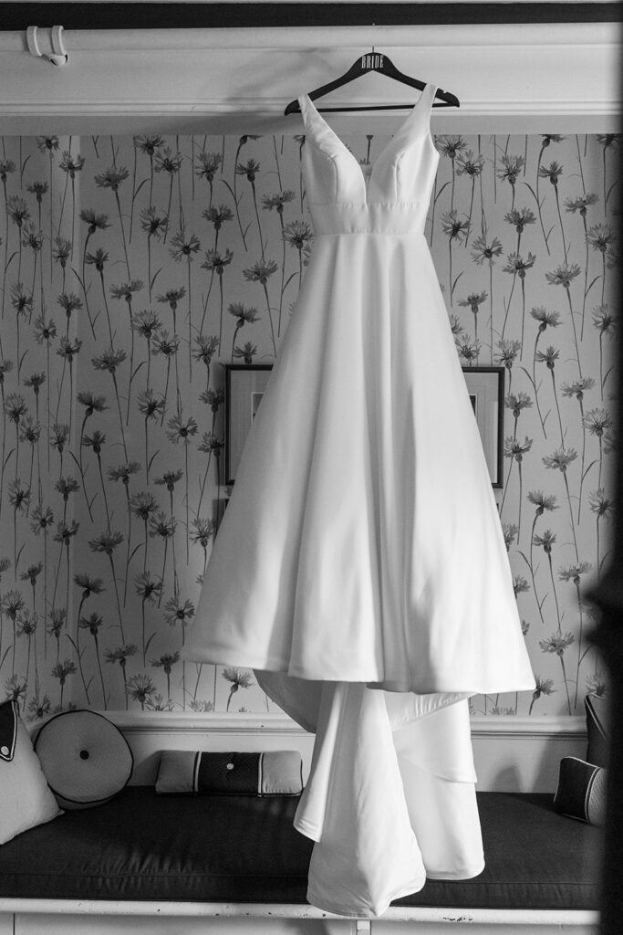 Detail shot of a bridal gown hanging up before the wedding photography timeline continues. 