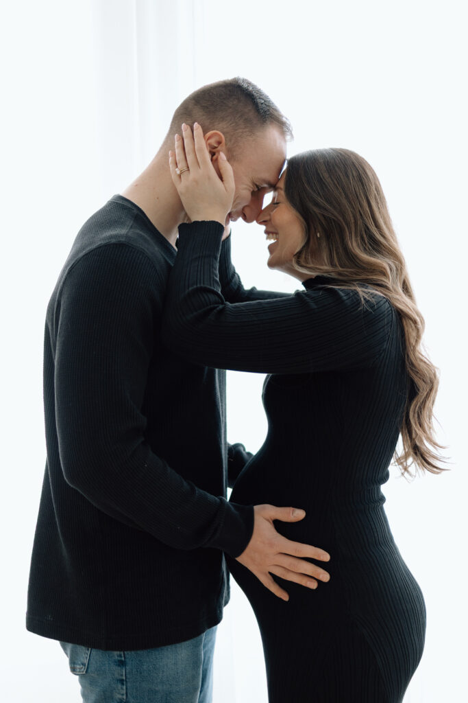 Husband holding his wife's pregnant belly during their maternity photos.
