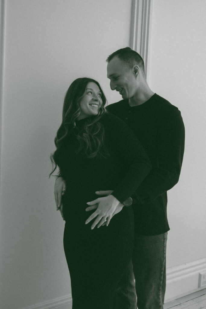 Couple smiling at each other for their luxury maternity photos.