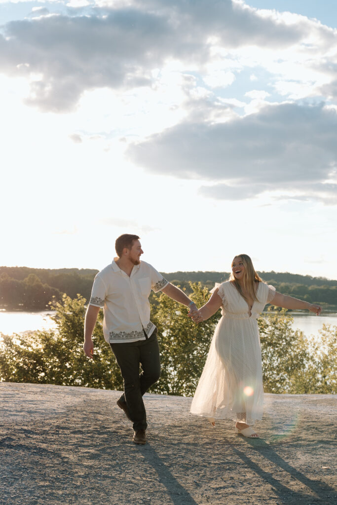 Engagement photo poses of a couple playfully walking hand in hand.